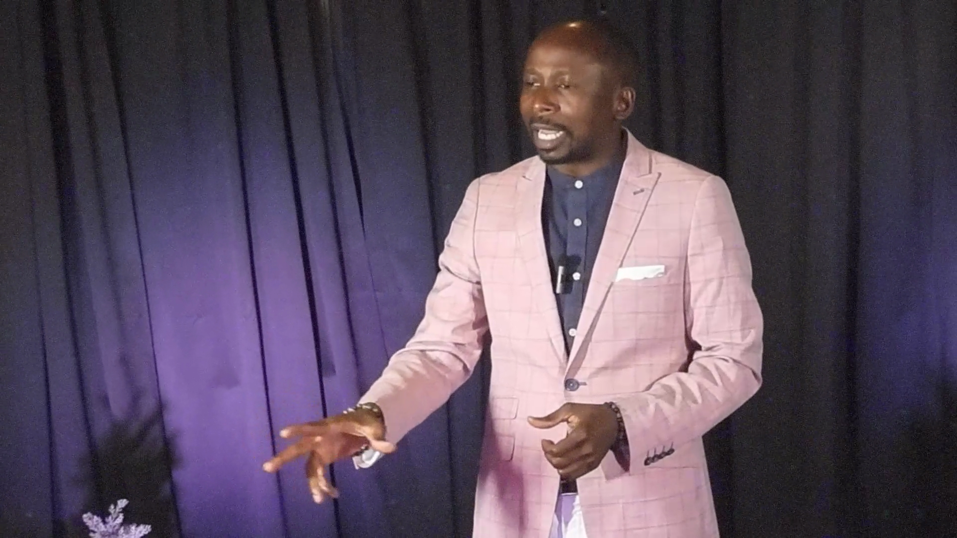 Amas on stage in pink blazer